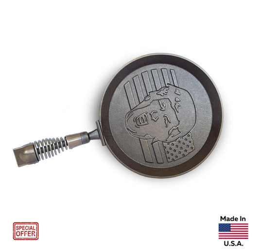 MAGA PANCAKES' limited edition hand-finished cast iron pancake skillet, MAGAPAN, with spring handle, and MAGA hardware hand-finished and cast in high-quality Bronze. Skillet is emblazoned with President Trump over an American flag.
