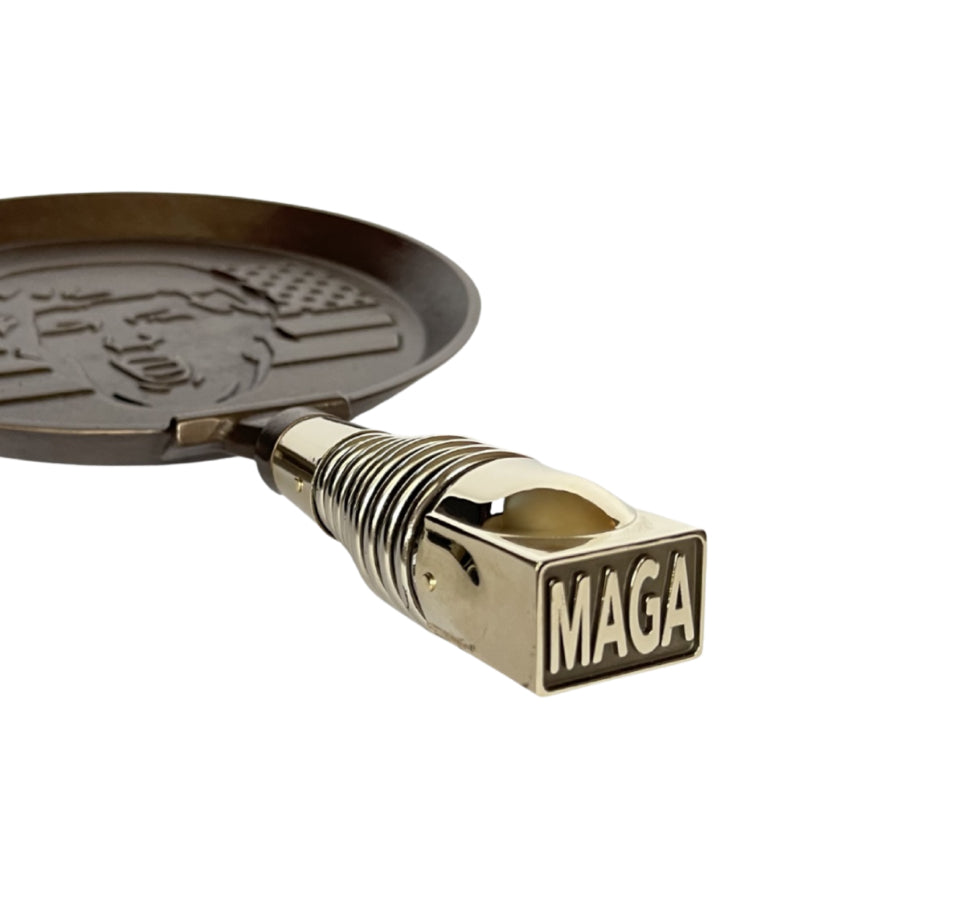 MAGA PANCAKES' commemorative President Trump skillet, MAGAPAN, hand-finished with spring handle hardware cast in high-quality Bronze, and given a patina before assembly that ages beautifully over time. Finish may naturally vary.